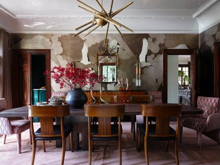 A de Gournay wallpaper wraps the dining room where vintage Klismos chairs join armchairs by Lancaster upholstered in a...