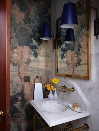 Pierre Freys Panoramic Au Bord du Lac wallpaper decorates a powder room. Sconces by The Urban Electric Co. flank the...