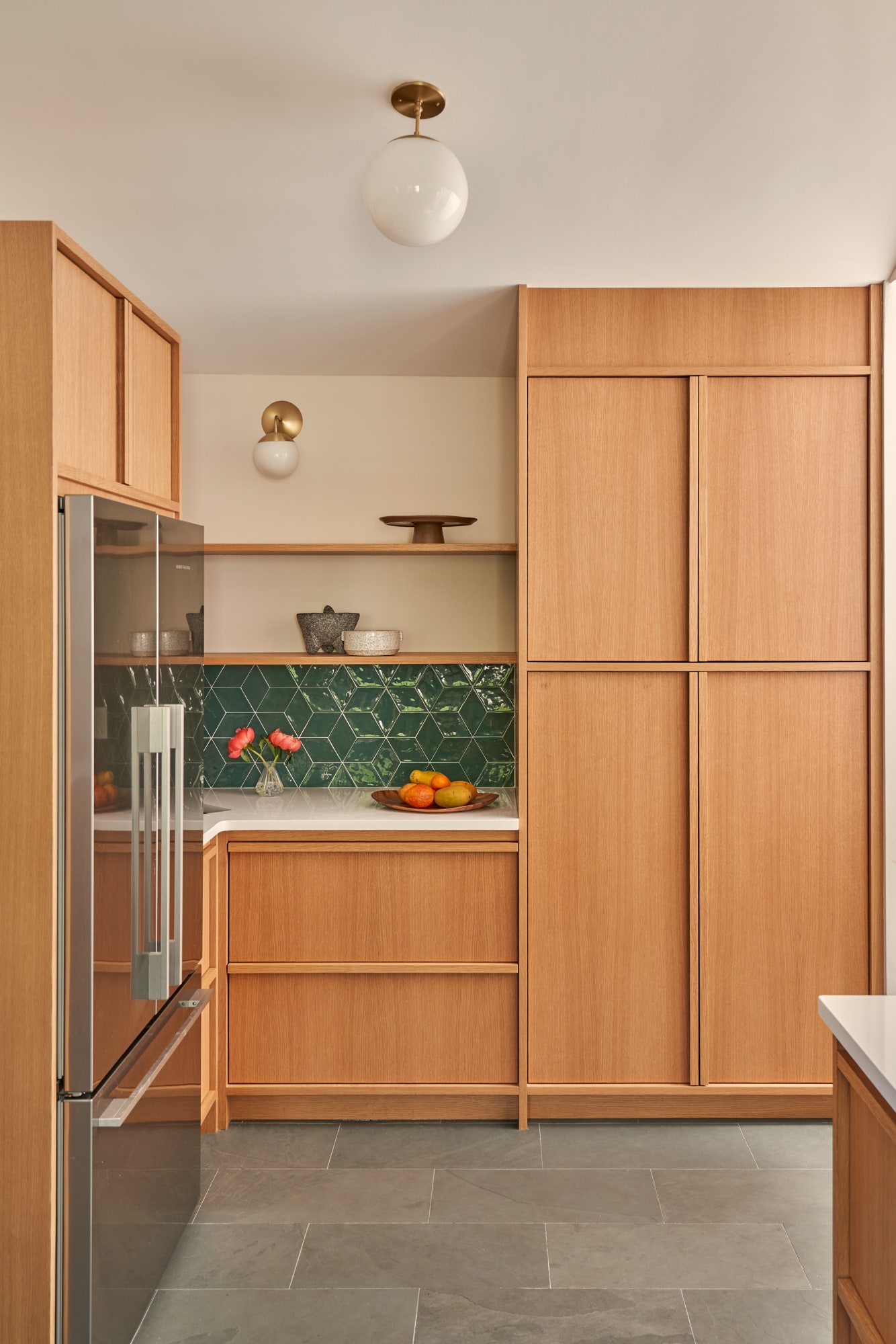 AFTER The new buildout is characterized by white oak cabinetry slate flooring and brass hardware. Adam had the cabinets...